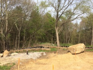 The dark iron pipe is the well head for the standing water column geothermal well (providing both heating/cooling and drinking water - 600' depth. The big rock was moved out of the way from where I am standing as the engineering firm of Stamski & McNary laid out the locations for the concrete piers for the house. Contrast to one week latter 