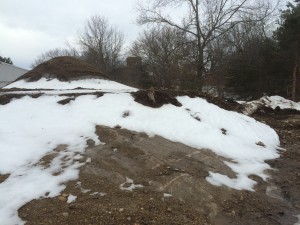 March 2014 view of the rock ledge under the knoll at my house. Pictures in May 2015 after fully excavating the site show that it is an enormous bubble of rock covering most of the site. The plan to mount and anchor the house on concrete piers pinned to the rock is turning out to have been a great idea