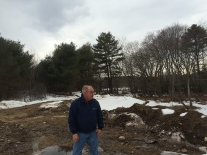 March 2015 looking from the knoll, back over the septic field with driveway starting from the left side of my dad and curving around to the right (behind him). This area turns out to be 100% rock ledge under us