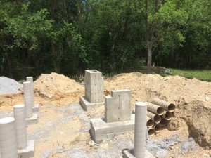 The round tubes are for bearing the weight of the house. The square concrete structure is a corner that is going to take later thrust as well as bearing weight. In the back is the foundation for the chimney stack - I am putting in a Rumford Fireplace 