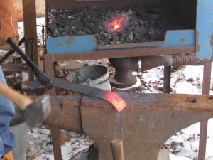 Flat bar stock at orange heat on the end - the technique we used on Mason's cookbook holder. You heat up the section you want and hammer it quickly while it is soft, before it starts to cool and harden back up. "Strike while the iron is hot!" comes from this saying.